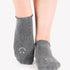 Women wearing gray grip socks with white smiley face for Pilates, Barre, Yoga, and beyond. 