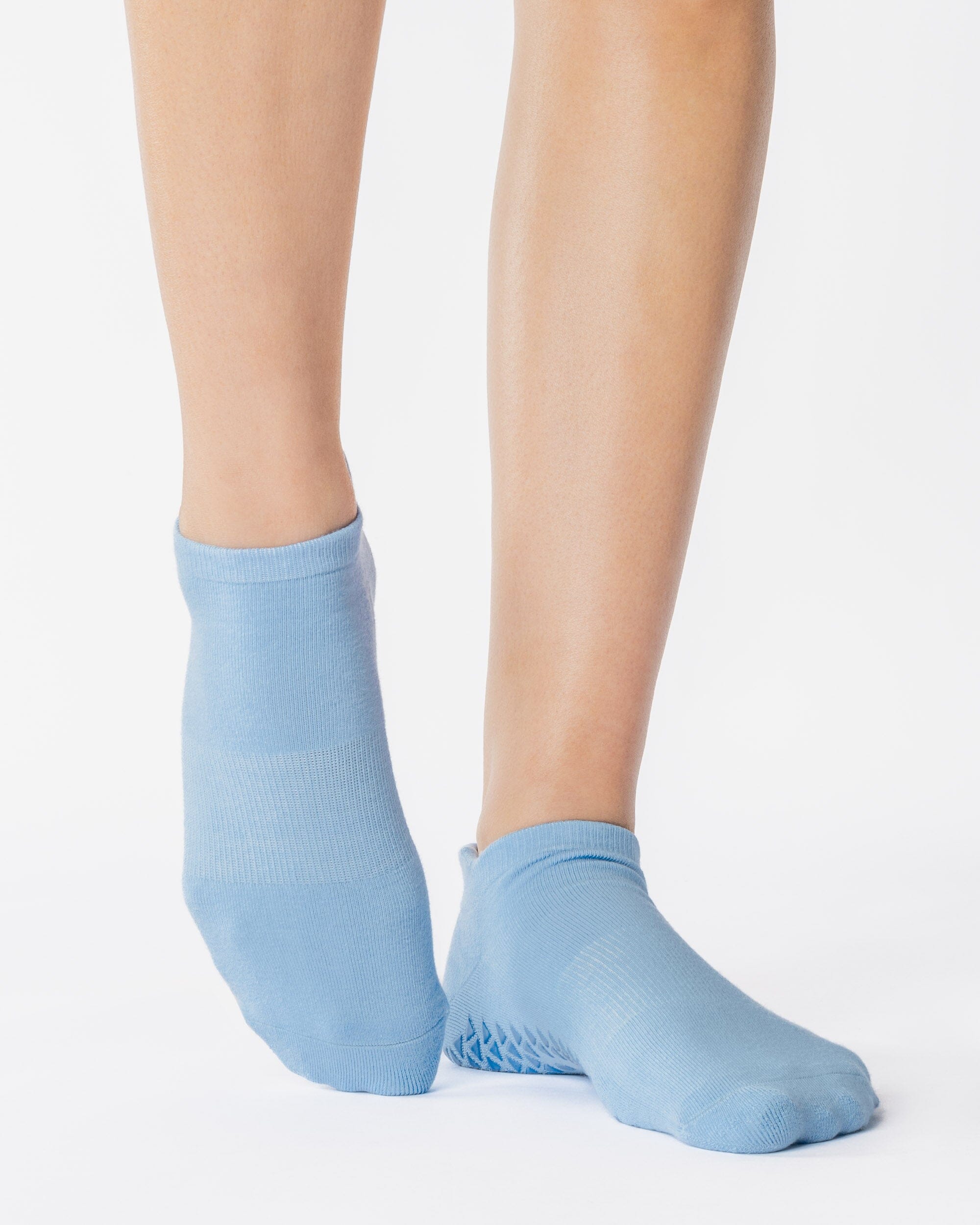 Women wearing a solid light blue full foot grip sock made for Pilates, Barre, Yoga, and beyond. 
