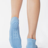 Women wearing a solid light blue full foot grip sock made for Pilates, Barre, Yoga, and beyond. 