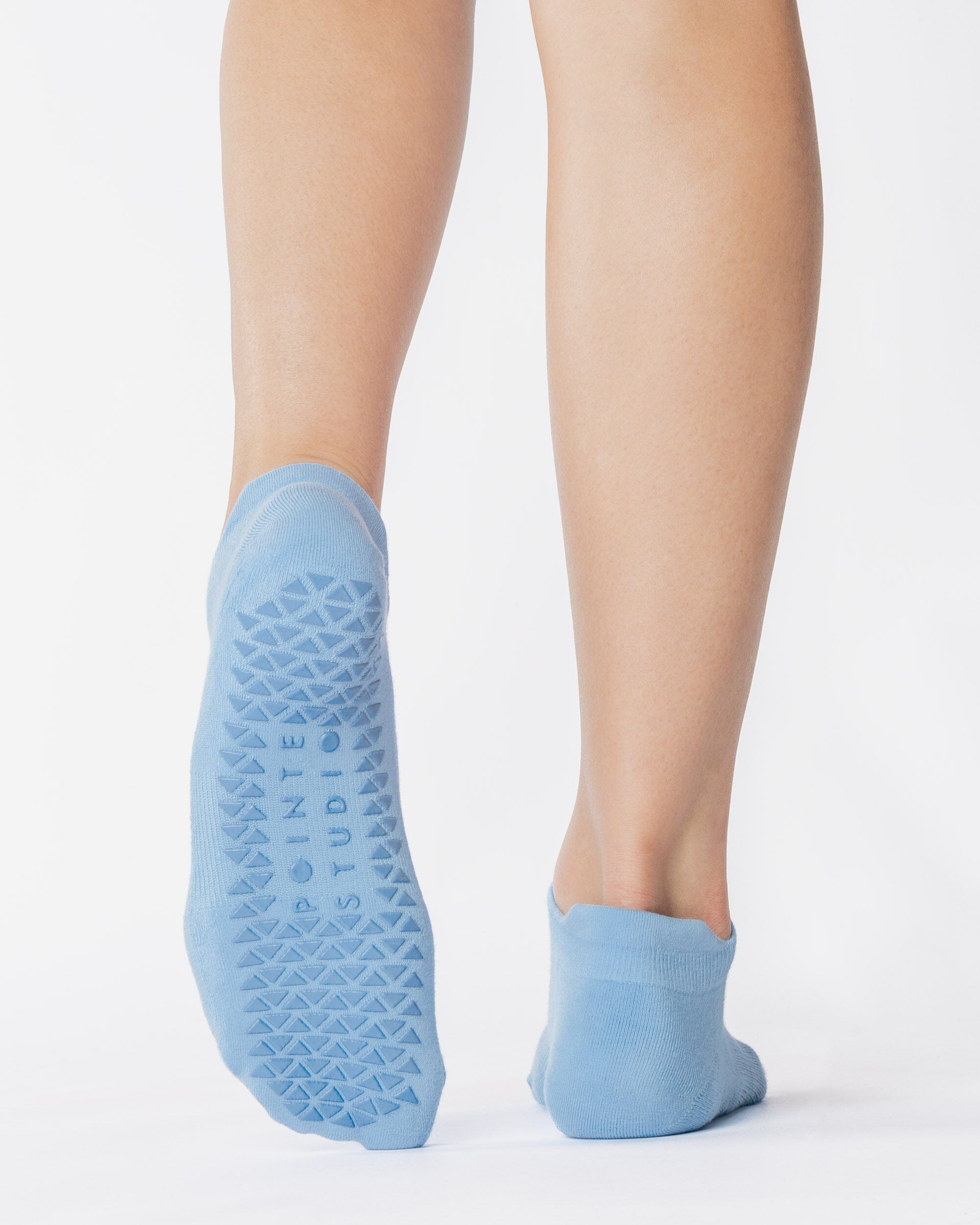 Women wearing a solid light blue full foot grip sock made for Pilates, Barre, Yoga, and beyond. 