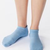 Women wearing a solid light blue full foot grip sock made for Pilates, Barre, Yoga, and beyond. 