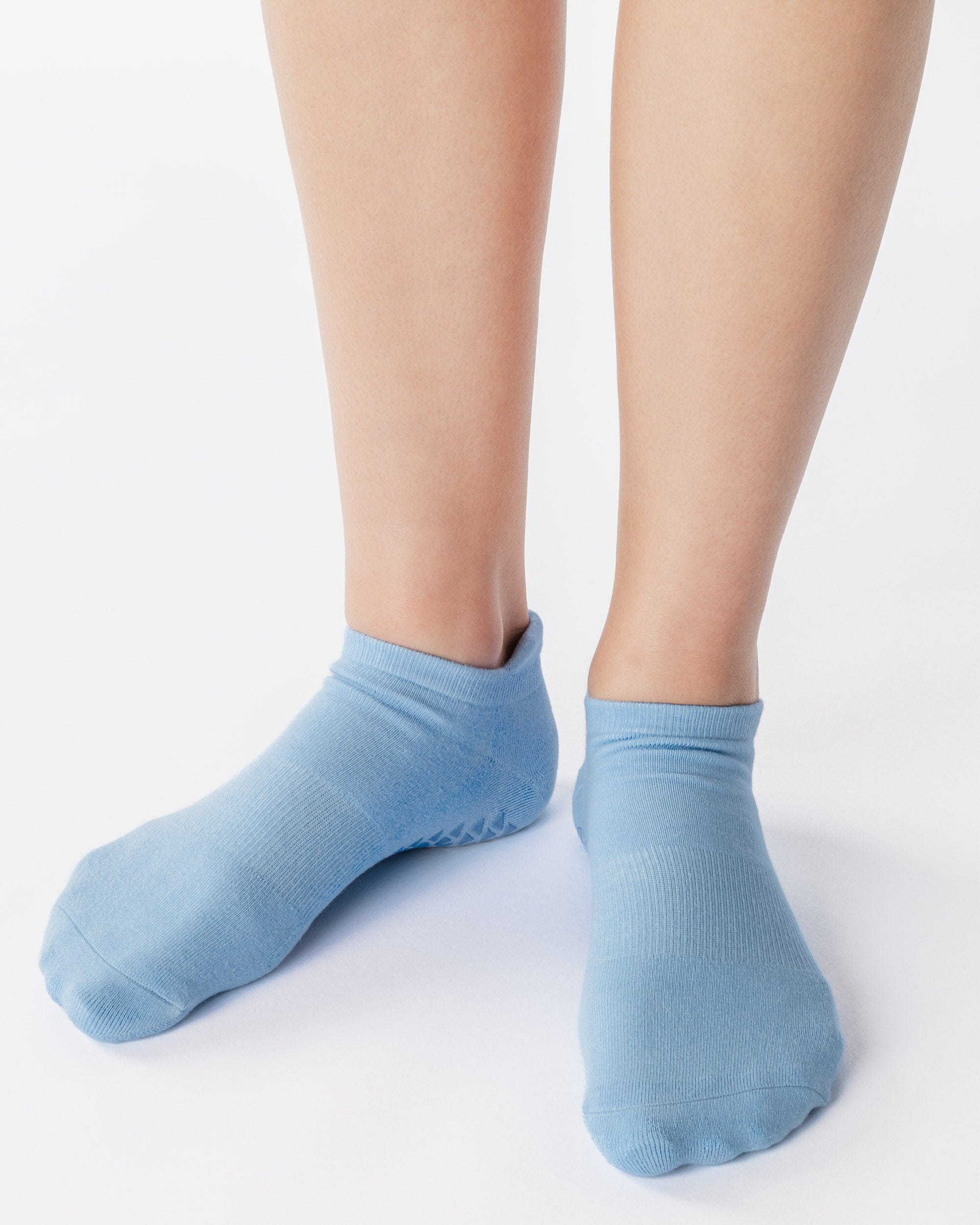 Women wearing a solid light blue full foot grip sock made for Pilates, Barre, Yoga, and beyond. 