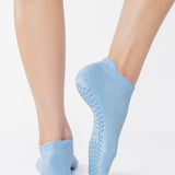 Women wearing a solid light blue full foot grip sock made for Pilates, Barre, Yoga, and beyond. 