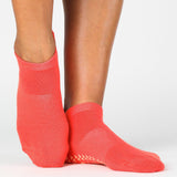 Women wearing a solid hot coral full foot grip sock made for Pilates, Barre, Yoga, and beyond. 