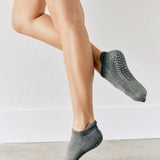 Women wearing a solid gray full foot grip sock made for Pilates, Barre, Yoga, and beyond. 