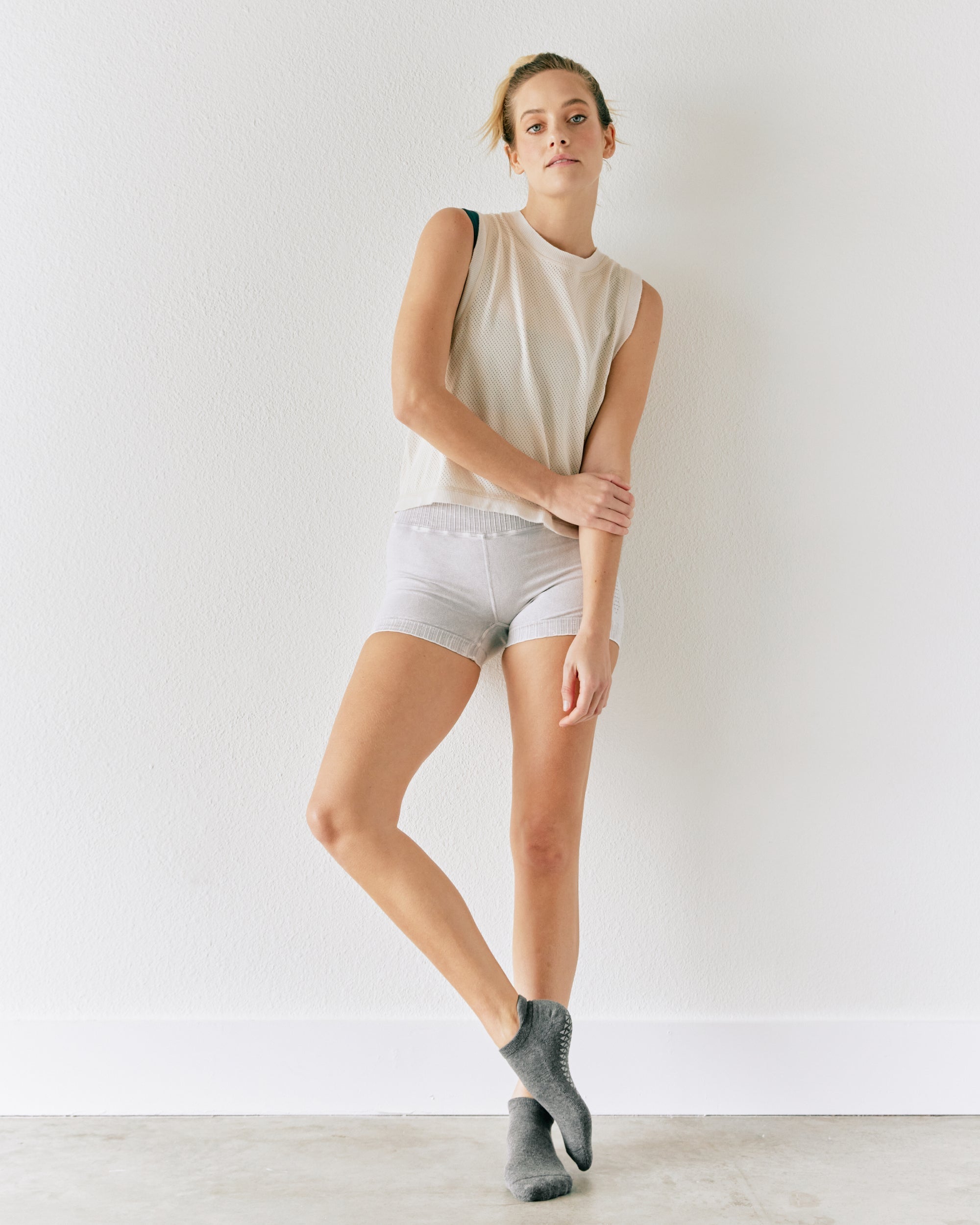 Women wearing a solid gray full foot grip sock made for Pilates, Barre, Yoga, and beyond. 