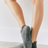 Women wearing a solid gray full foot grip sock made for Pilates, Barre, Yoga, and beyond. 