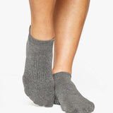 Women wearing a solid gray full foot grip sock made for Pilates, Barre, Yoga, and beyond. 