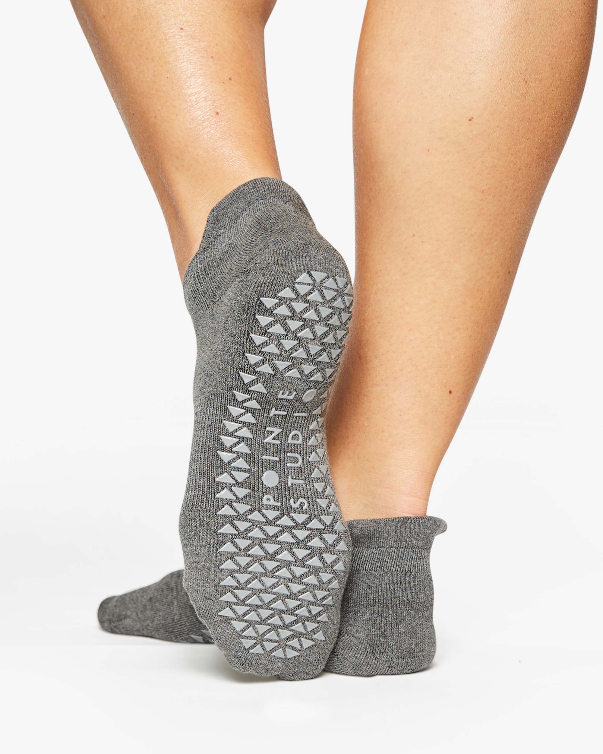 Women wearing a solid gray full foot grip sock made for Pilates, Barre, Yoga, and beyond. 